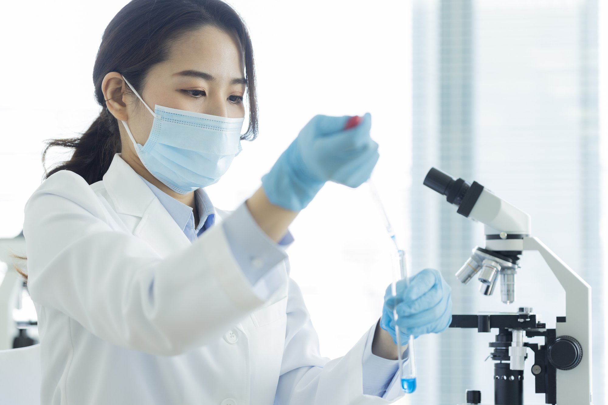 検体を試験管に写している女性の検査技師.jpg